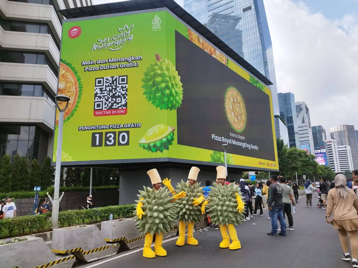 Interactive LED billboard with a QR code game and a live prize counter, with costumed mascots in front