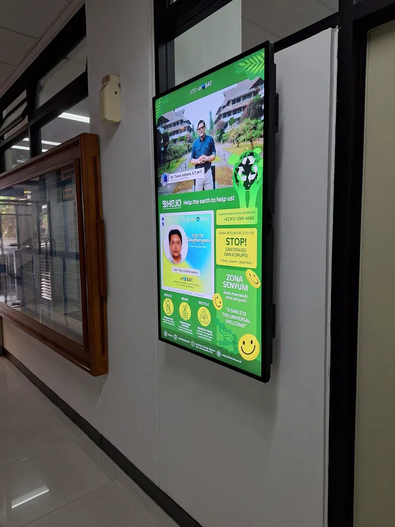 Wall-mounted screen at STEI showing a message from the dean and school announcements