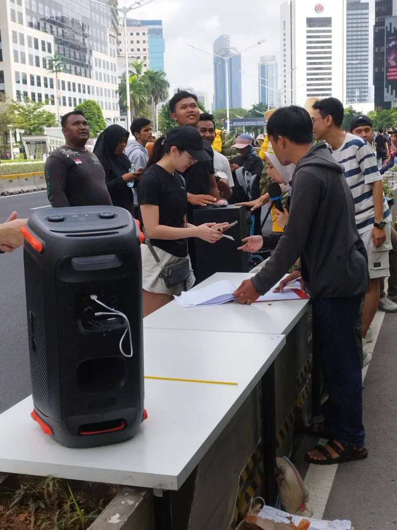 Participants checking in at the button station in front of the screen