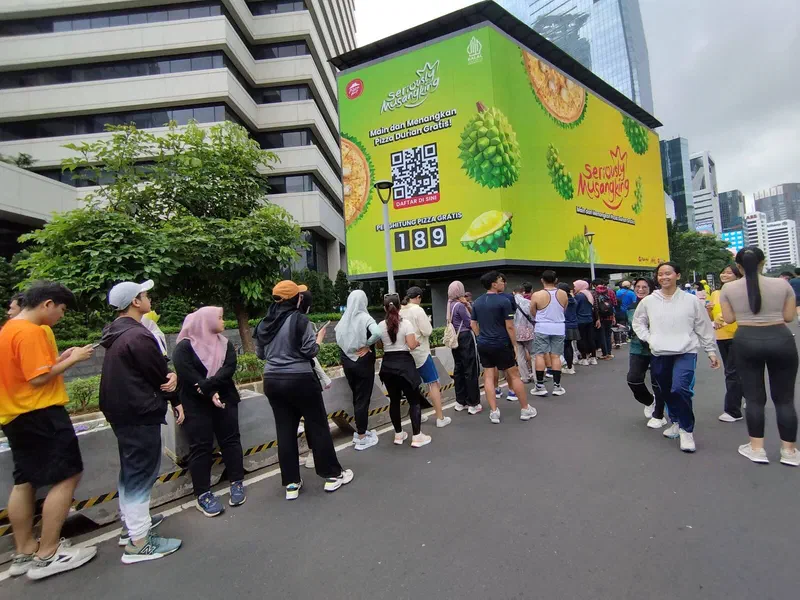 Participants queueing along the road in front of the Seriously Musangking LED videotron