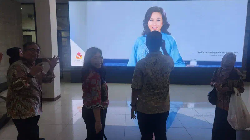 Guests in front of the lobby videotron showing a personal welcome